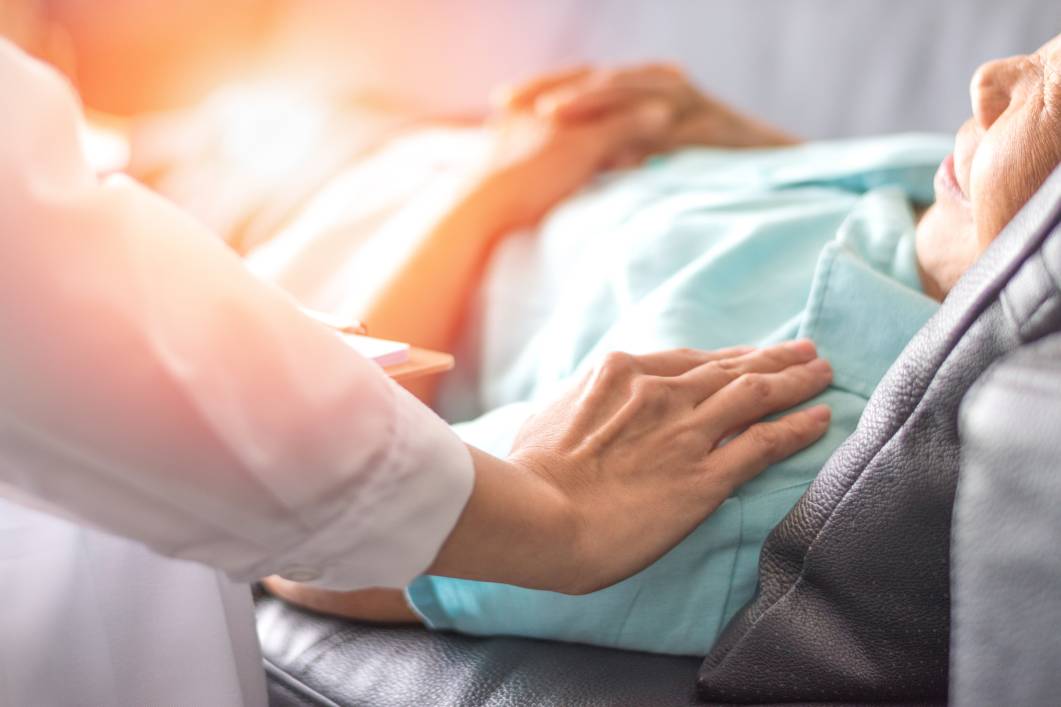 Caretaker placing comforting hand on patient's shoulder